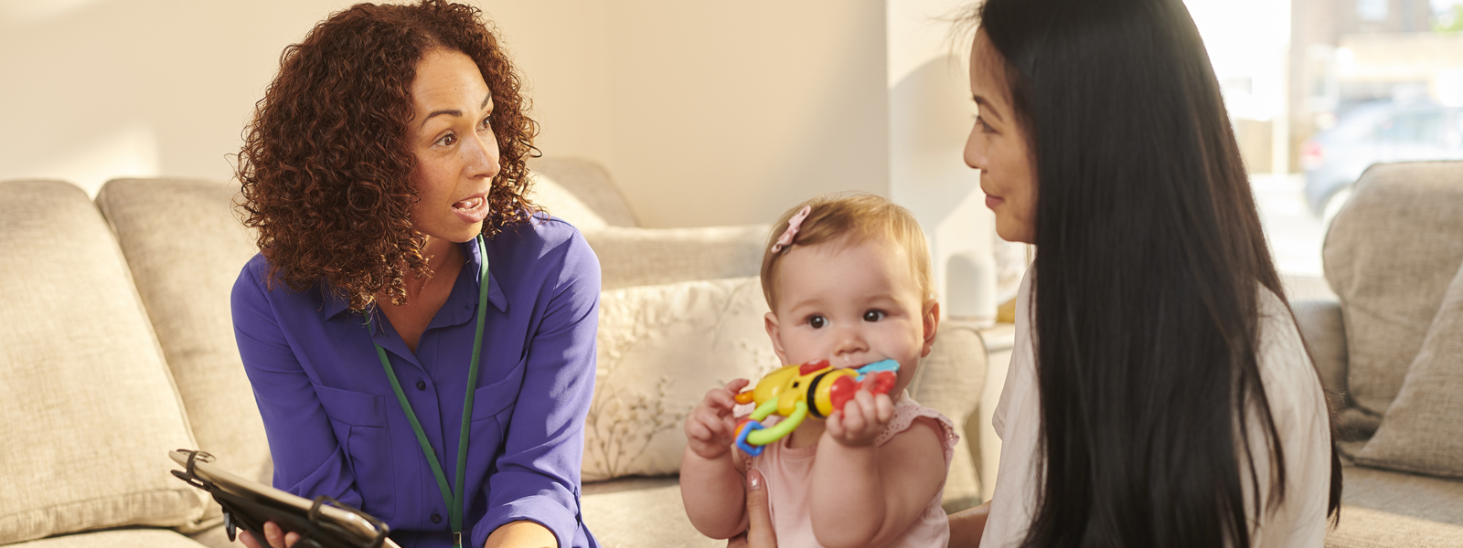 home visitor talking to parent who is holding baby